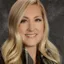 Smiling blonde woman with wavy hair.